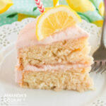 slice of pink lemonade cake with a slice of lemon on top