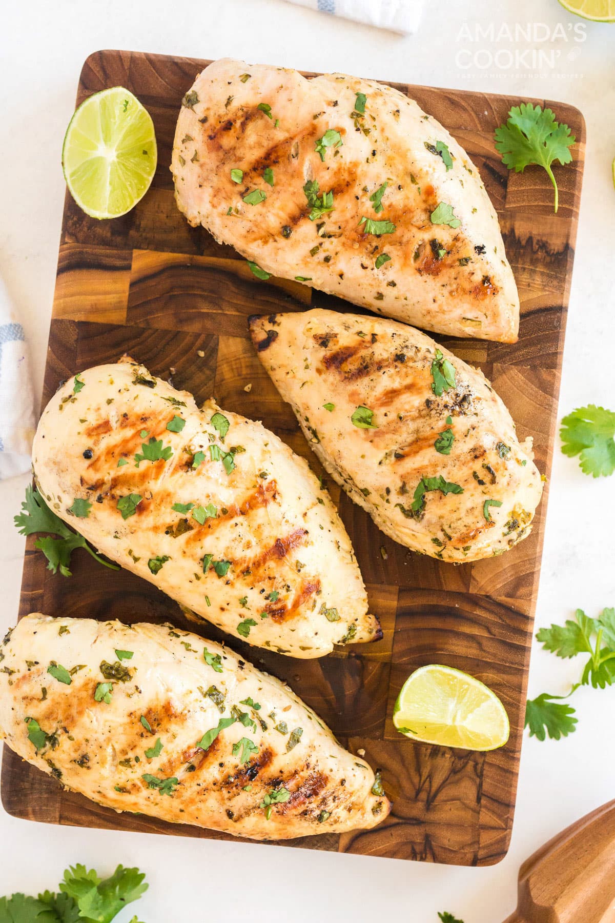 grilled chicken breasts on a wood cutting board