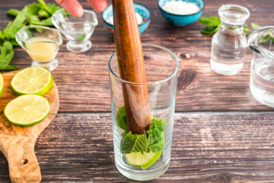 muddling mint and lime in glass