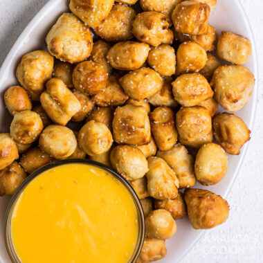 overhead view of pretzel bites on a plate with cheese sauce