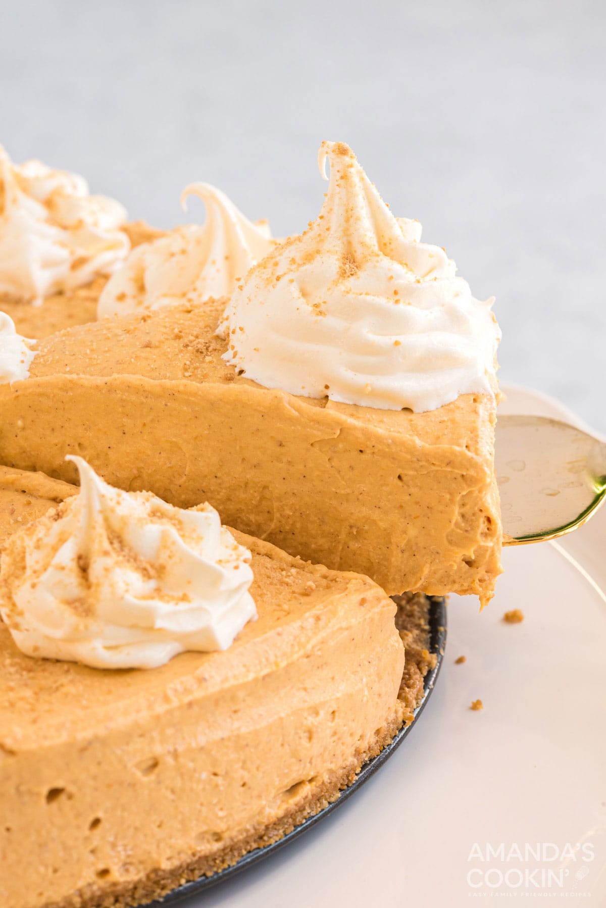 removing a slice of no bake pumpkin cheesecake with a pie server