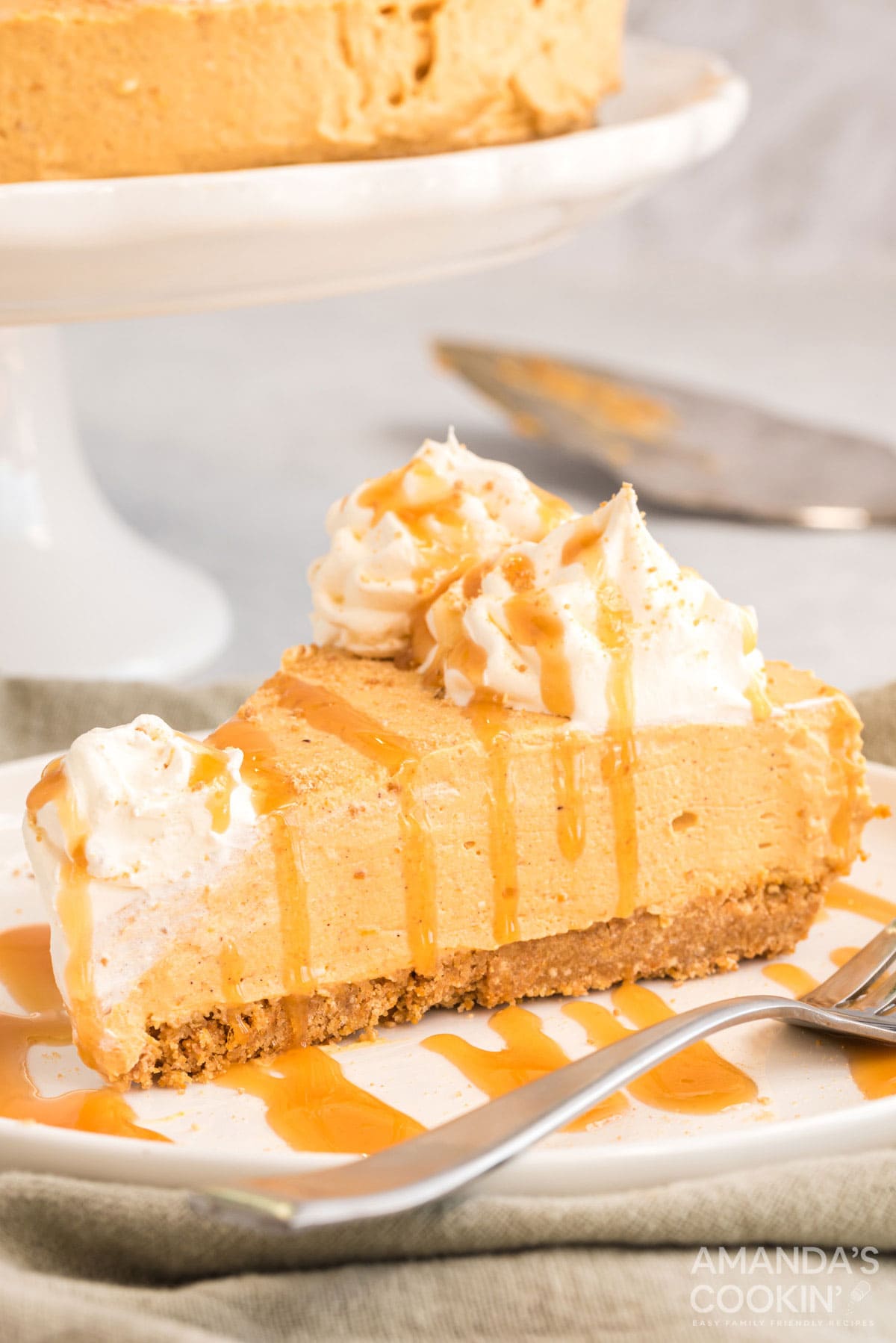 slice of no bake pumpkin cheesecake on a plate drizzled with caramel