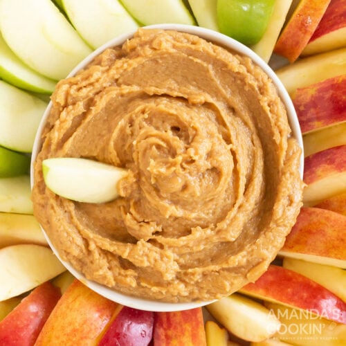 cowl of peanut butter apple dip surrounded by apples