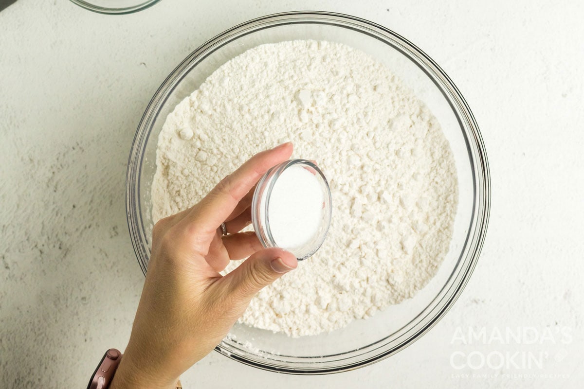 adding salt to flour in a bowl