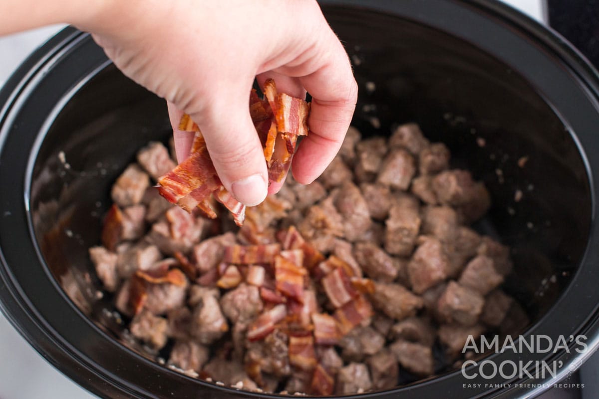 sprinkling bacon over beef