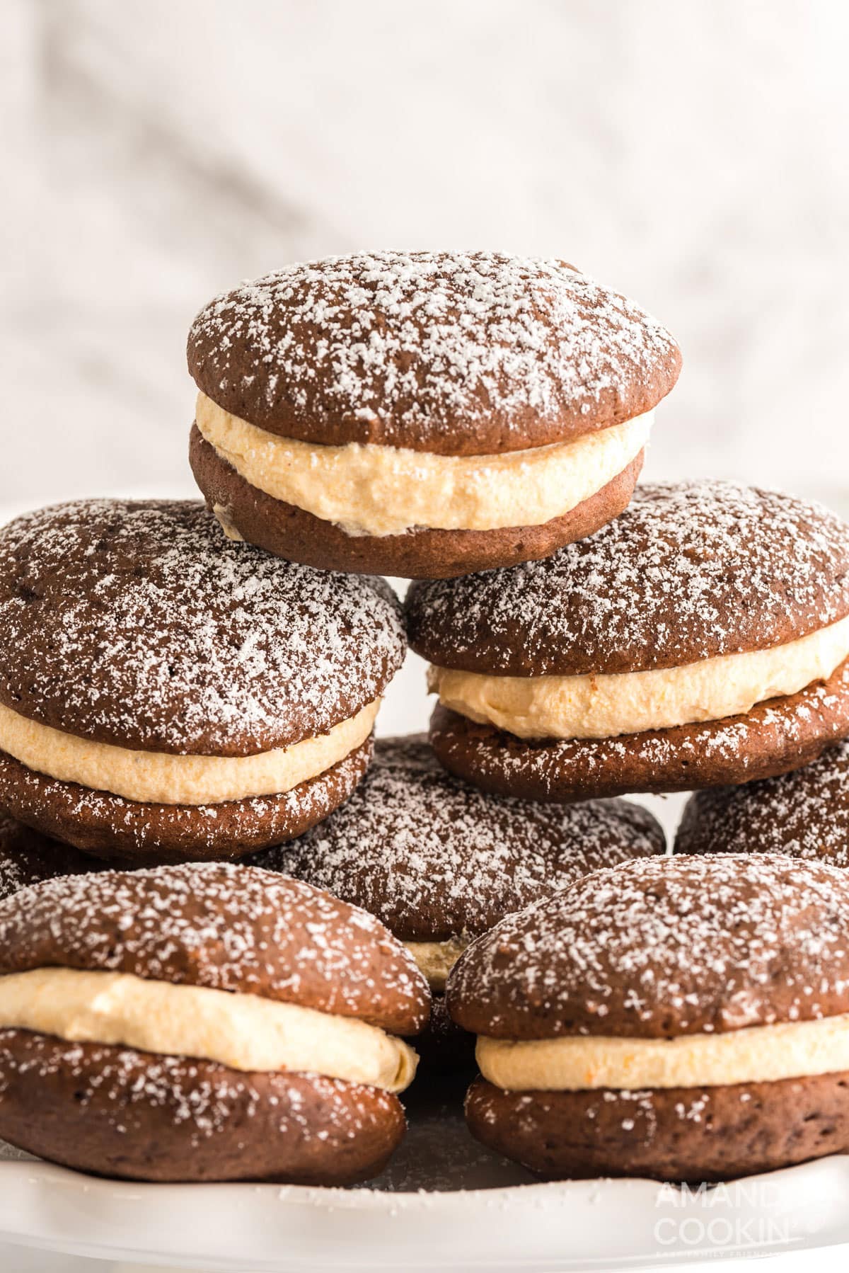 stack of pumpkin whoopie pies dusted with powdered sugar