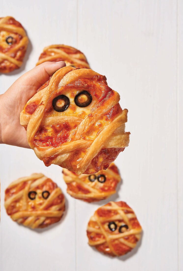 child holding mini mummy pizza