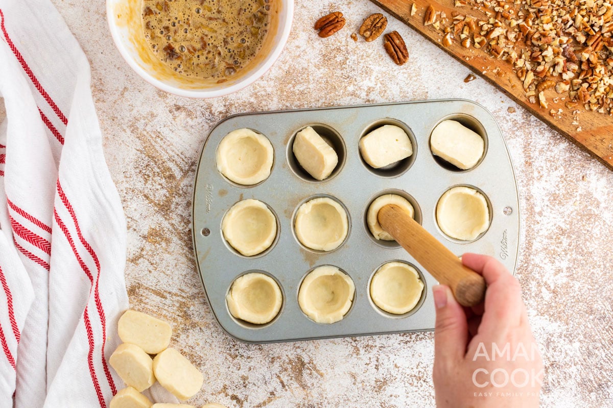 pressing dough in muffin tin