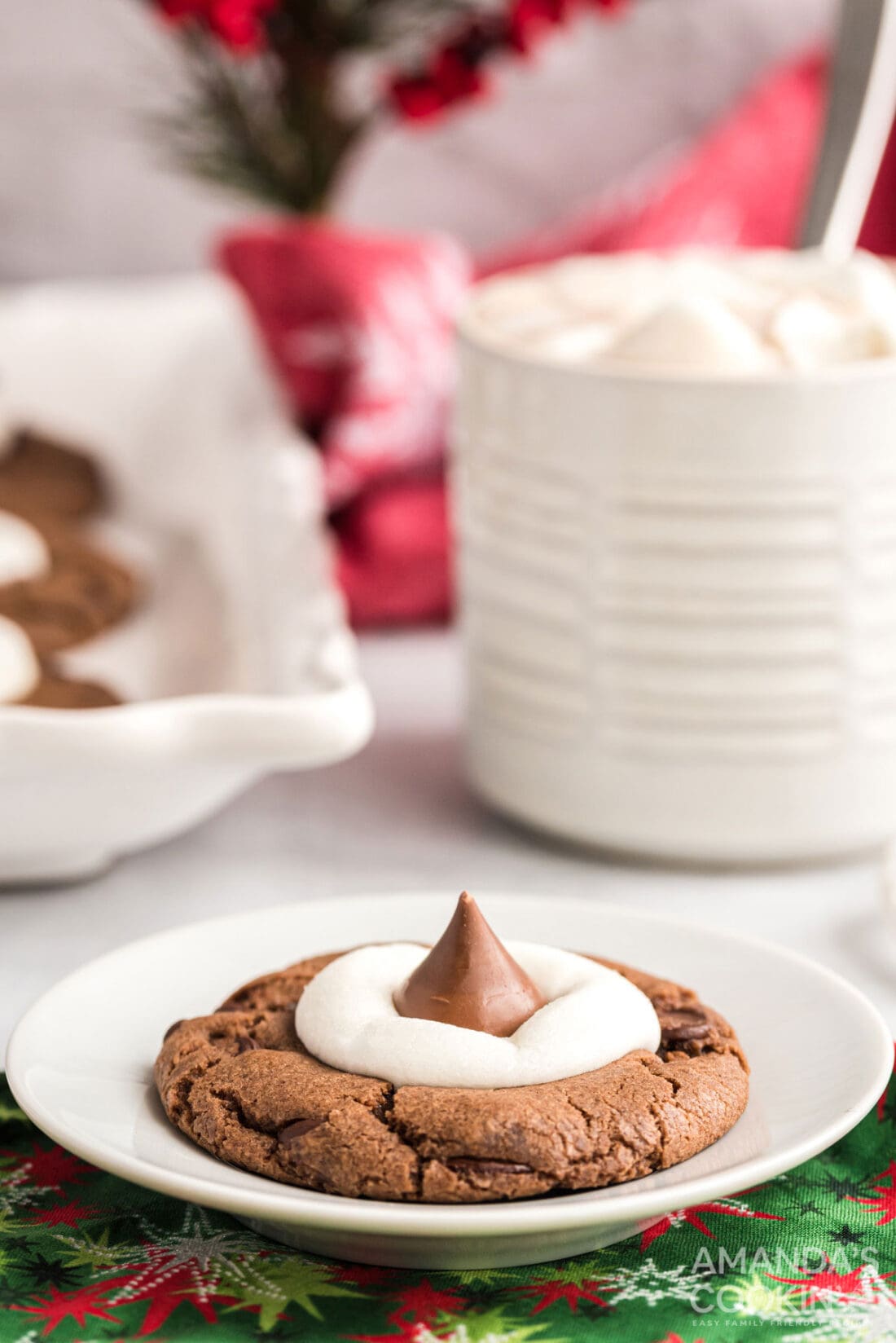 hot cocoa cookie on a plate with mug in background