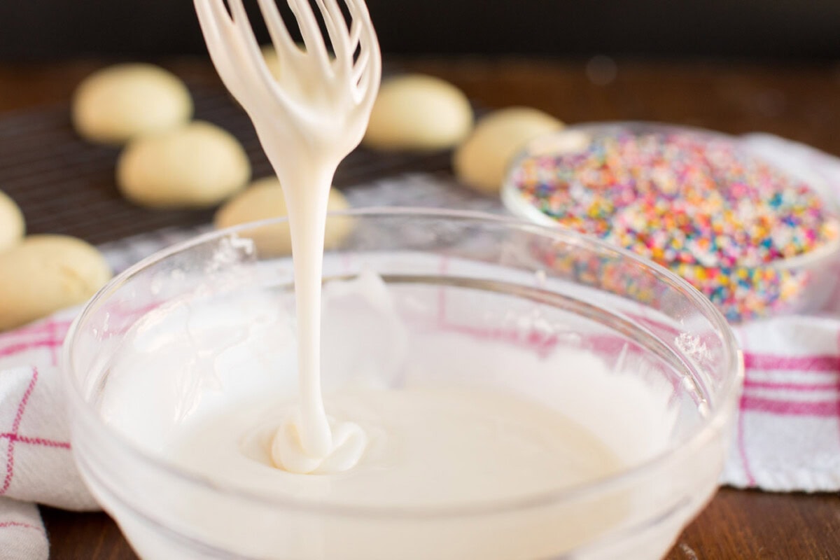 lifting glaze with whisk to show thickness