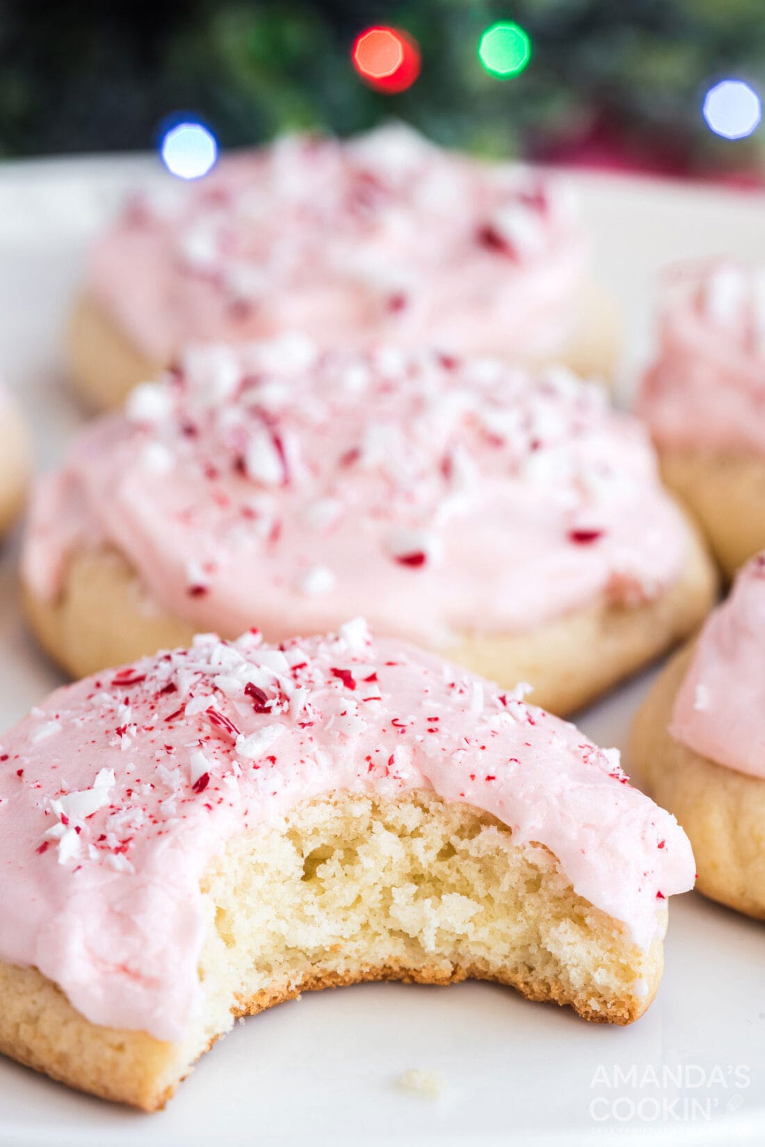 pink frosted peppermint cookie with a bite out of it
