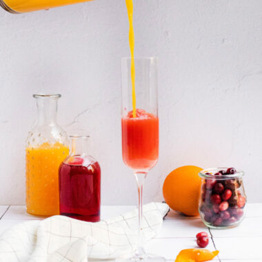 pouring orange juice into a chamagne flute