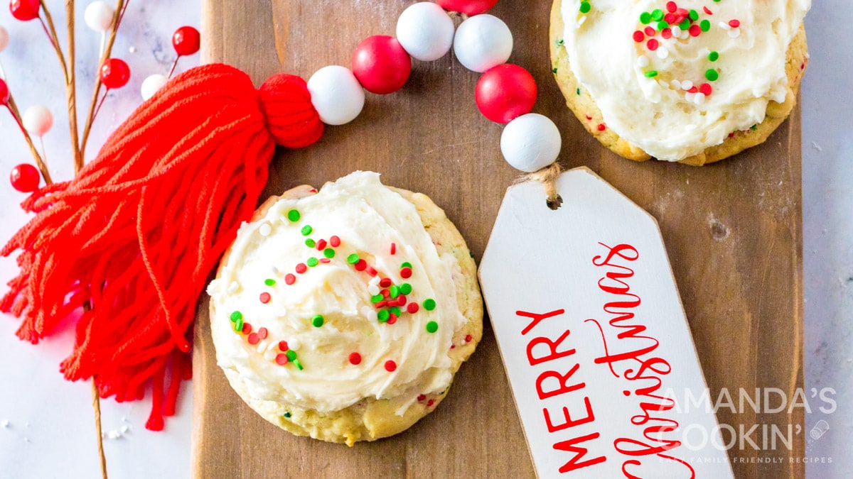 cake mix cookies with christmas sprinkles and frosting on cutting board