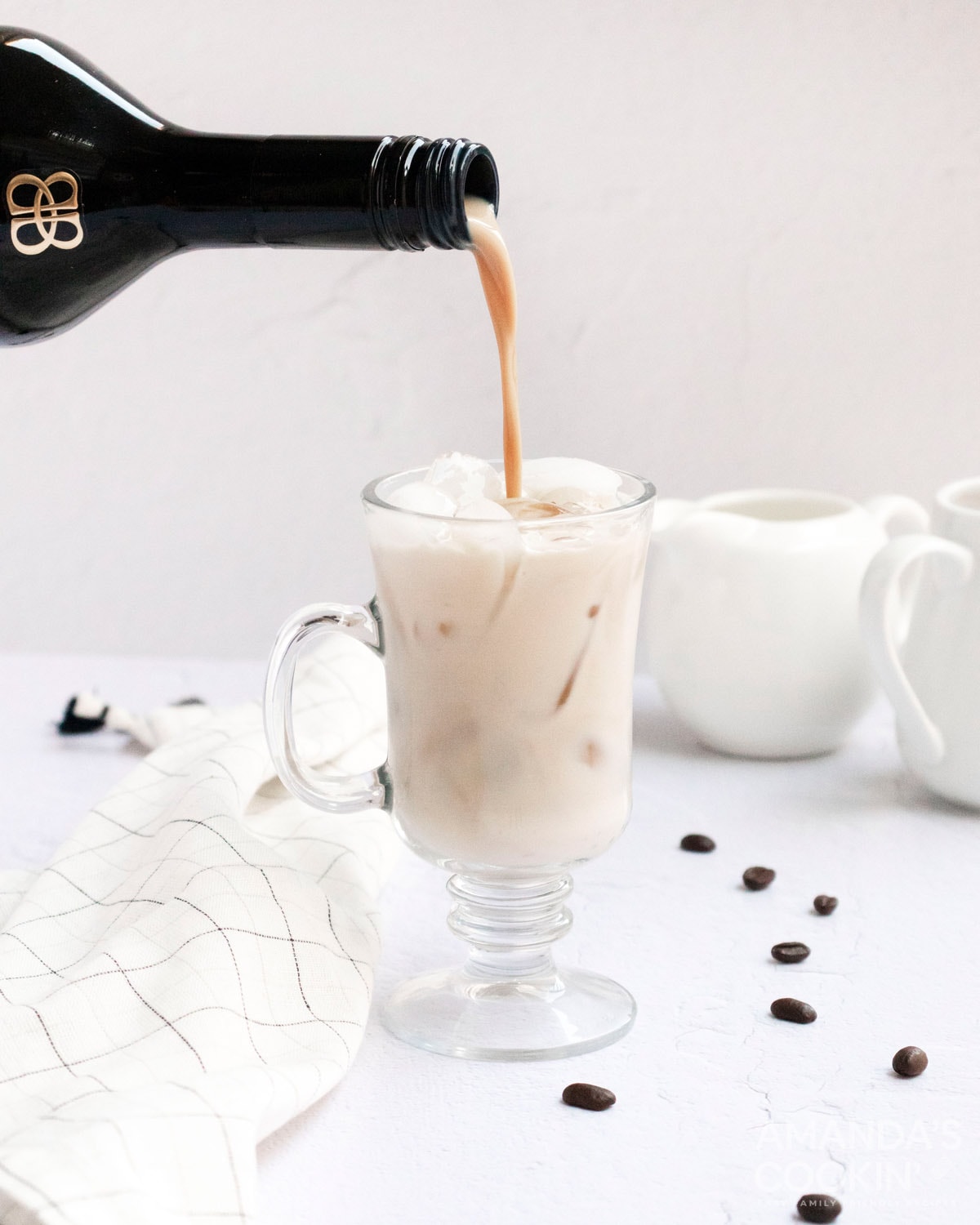 pouring baileys into a white russian
