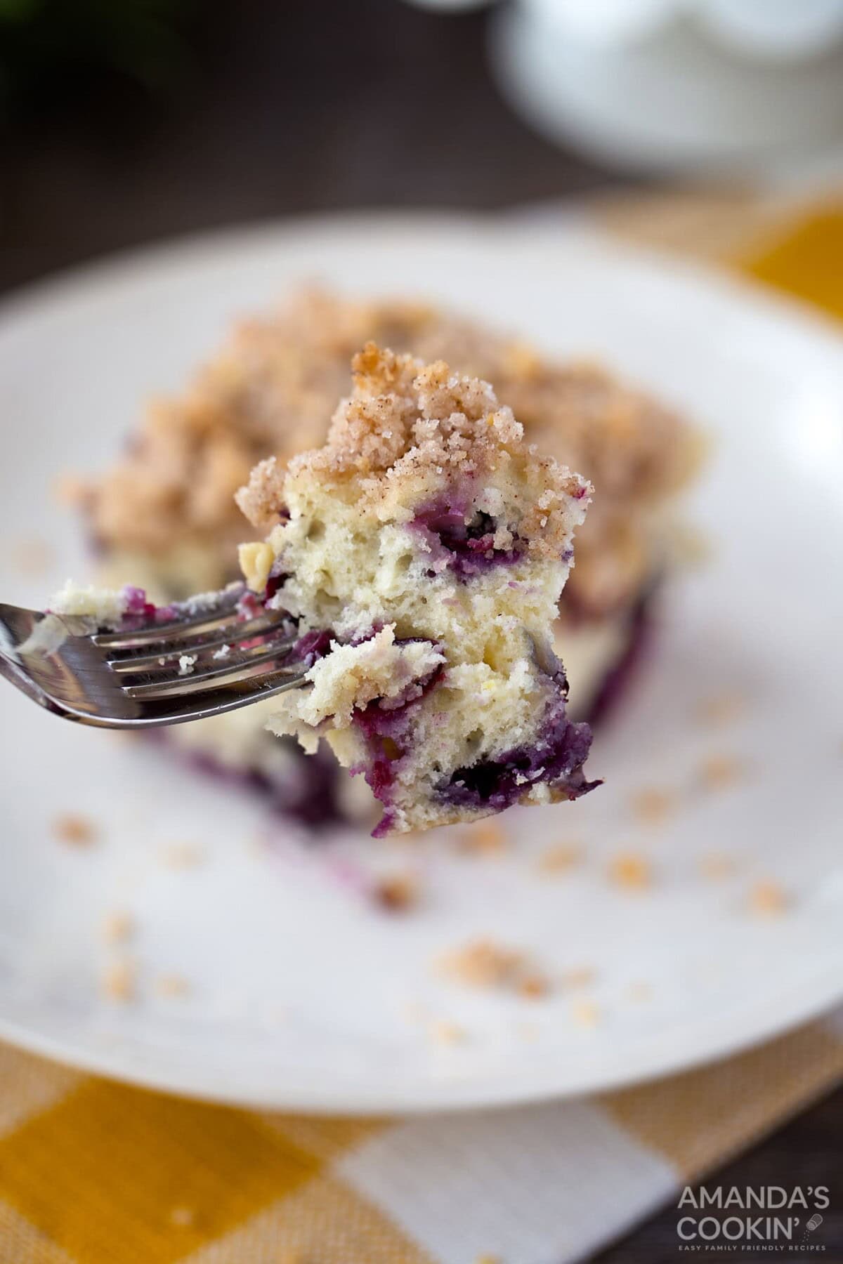 Blueberry breakfast cake, coffee cake, whatever you want to call it, it's overflowing with blueberries and absolutely delicious. #blueberrycake #blueberrycoffeecake #blueberrybuckle #blueberrydessert #blueberries #coffeecake #coffeecakerecipes #breakfastcake #recipesforblueberries fork of blueberry breakfast cake