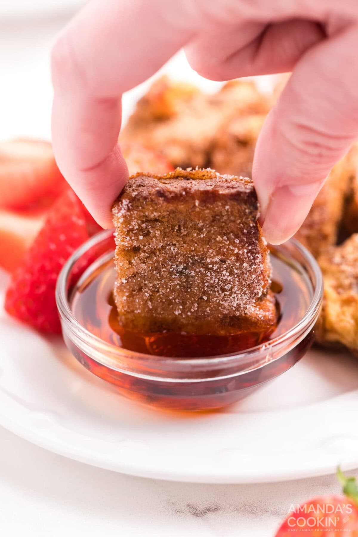 dipping a french toast stick in syrup