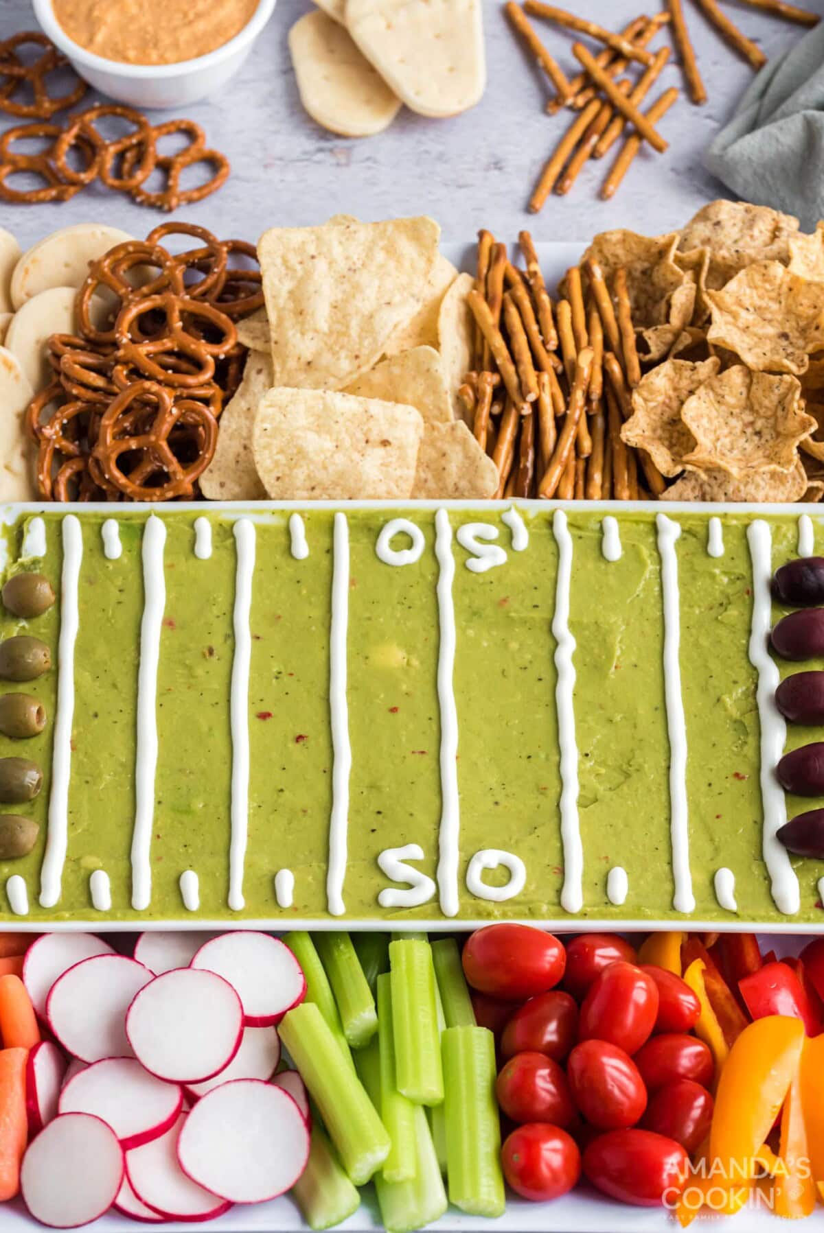 football party tray with guac, veggies, and crackers