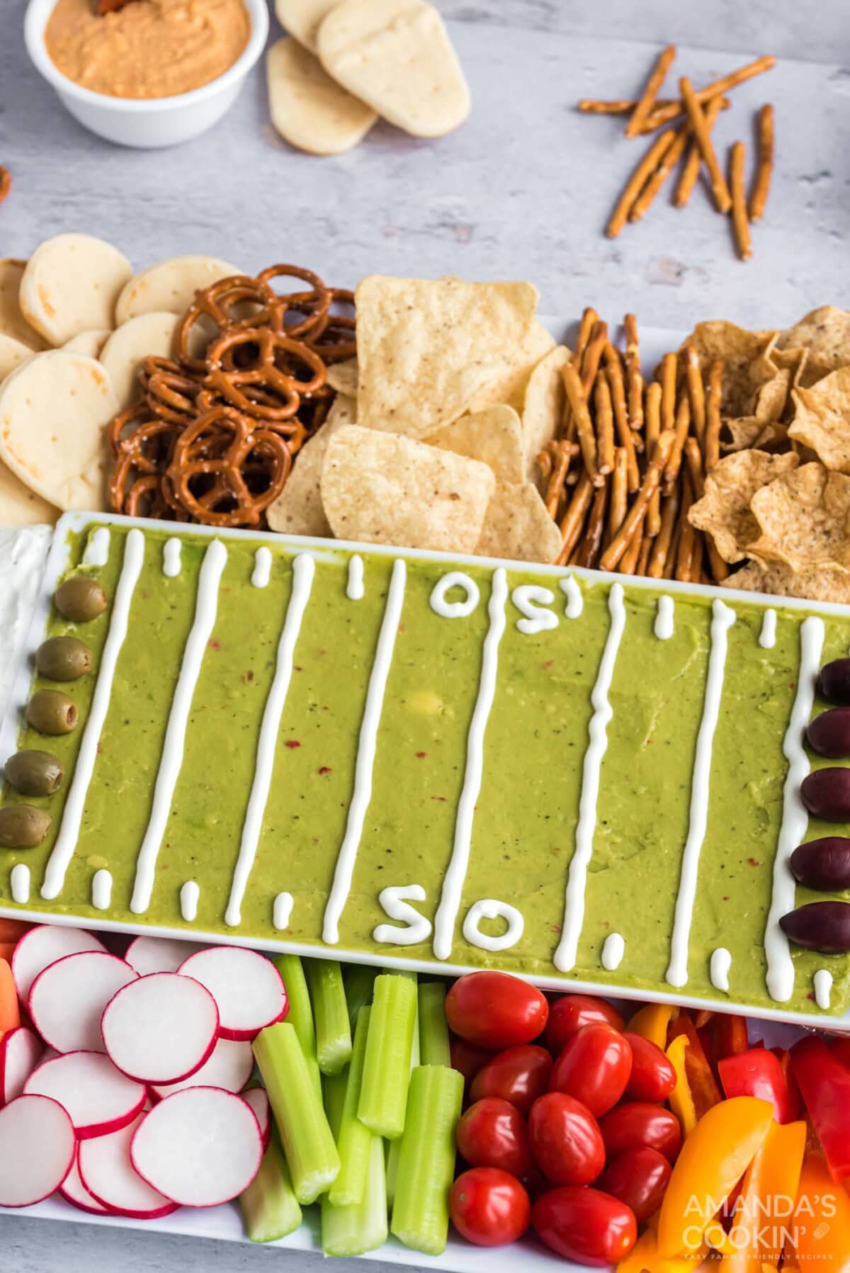 football party tray with guac, veggies, and crackers