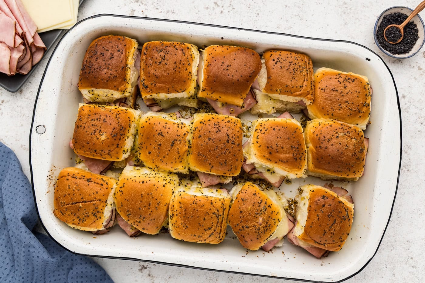 golden baked ham and cheese and sliders in a baking pan