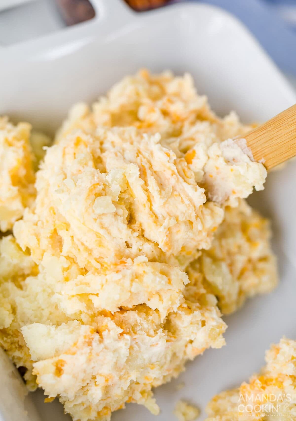 scooping mashed potatoes into a casserole dish