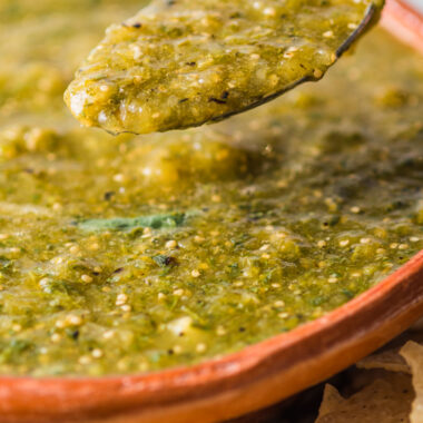 spoon lifting some salsa verde from bowl