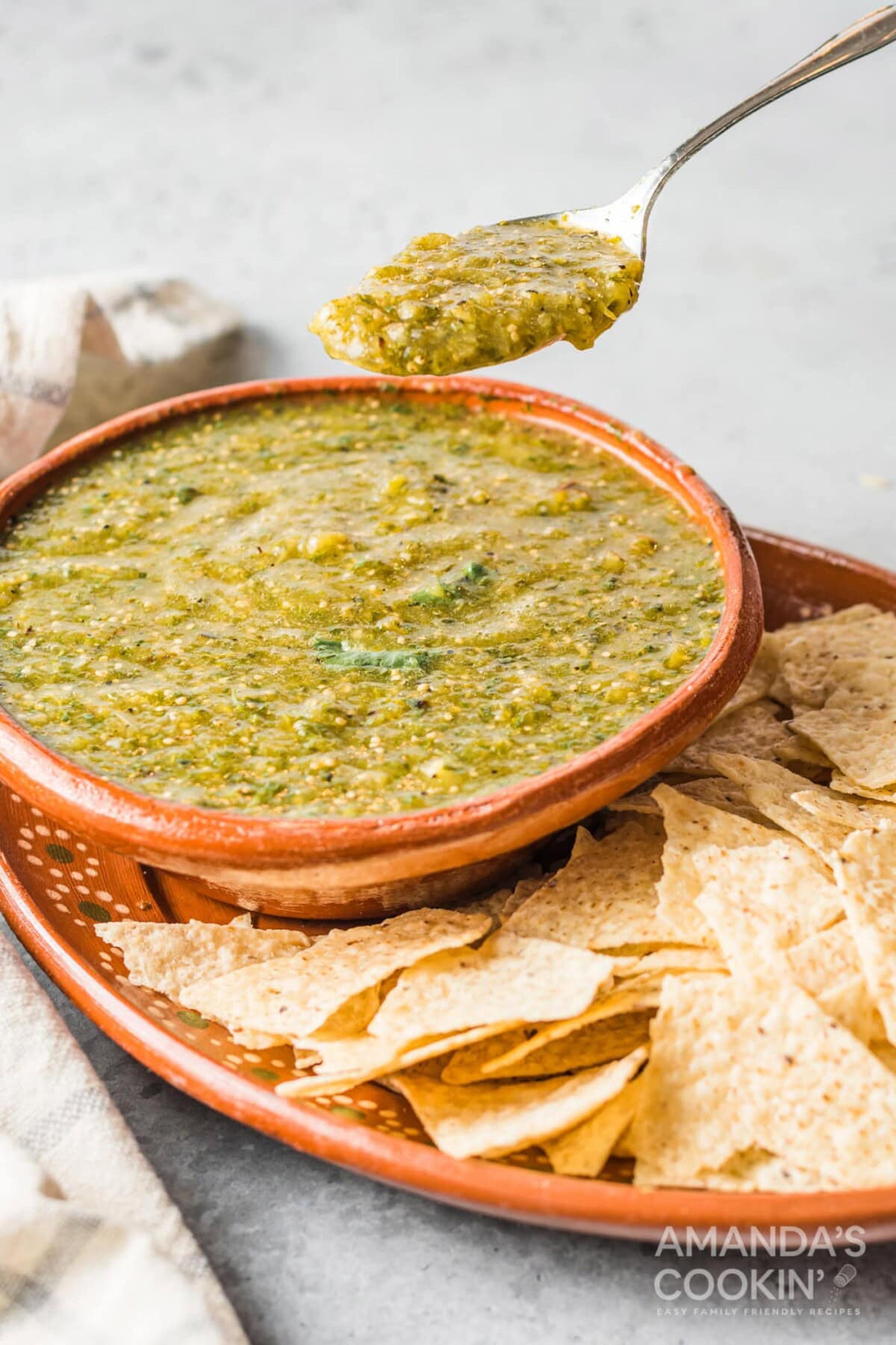 spoon lifting some salsa verde from bowl