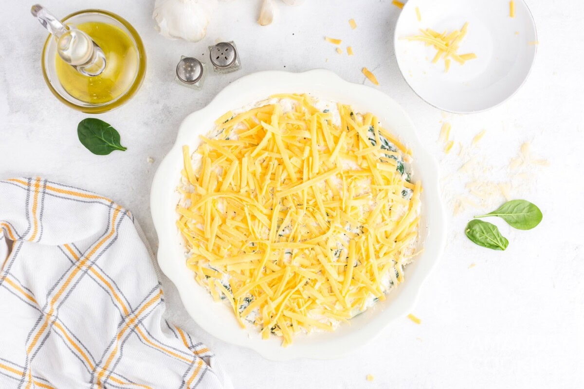 topping the spinach dip with cheese
