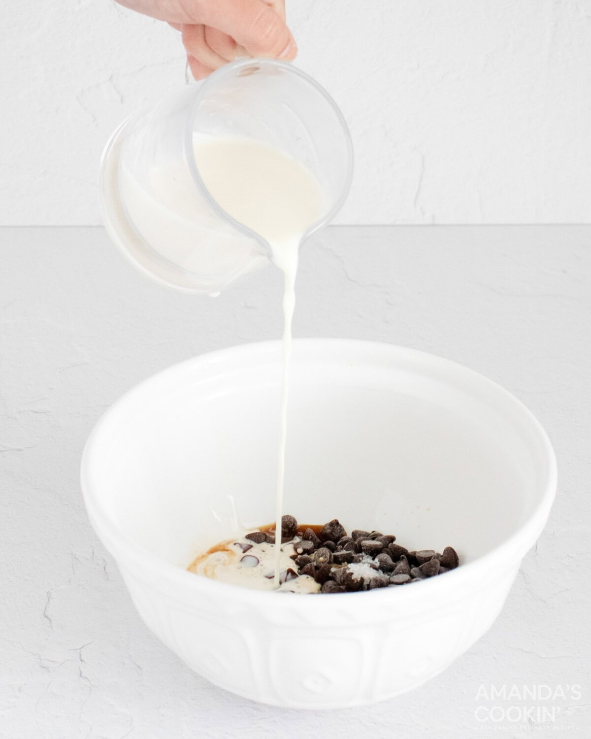 adding warm cream to bowl of ingredients
