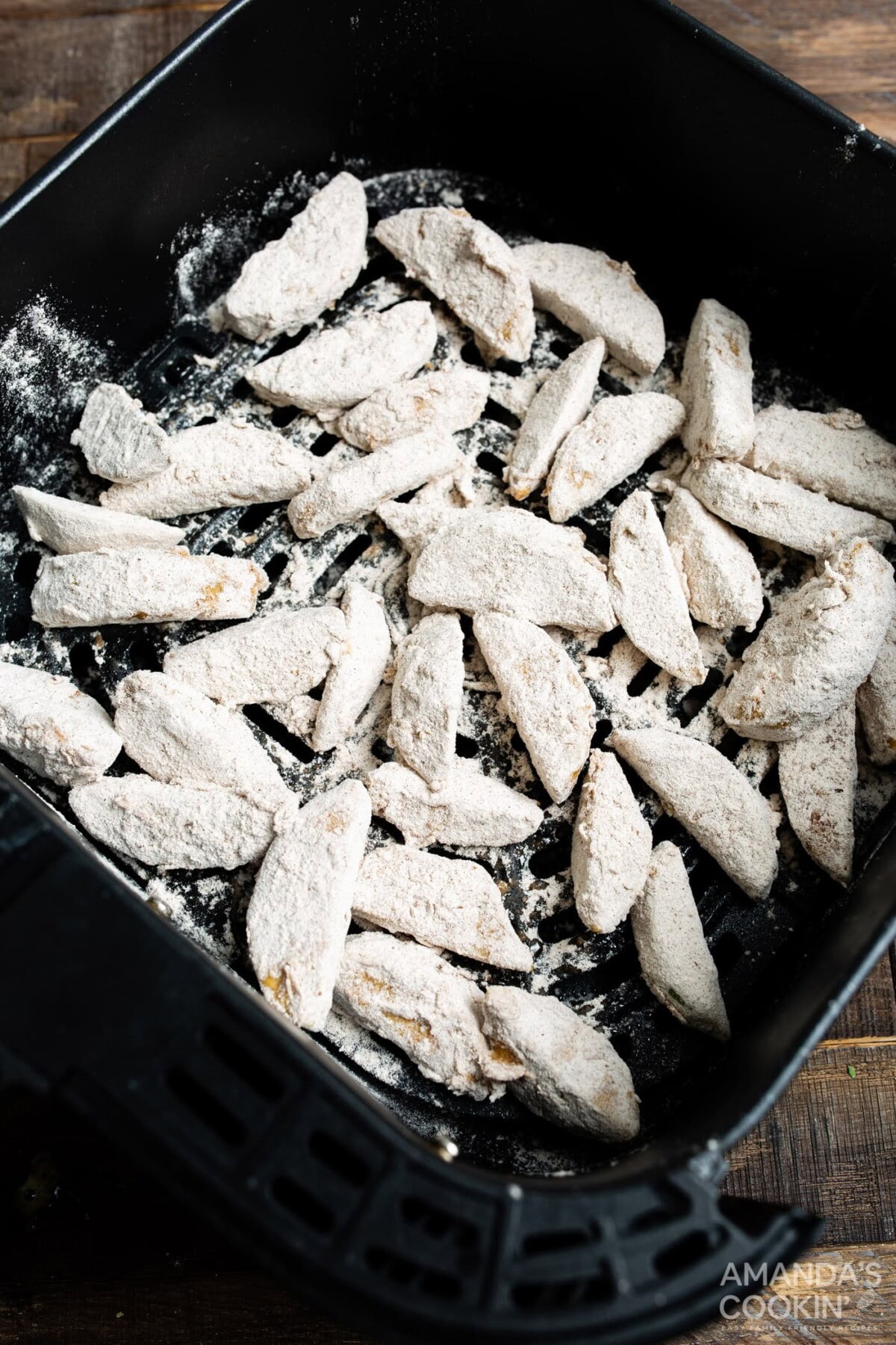 floured apple slices in air fryer basket
