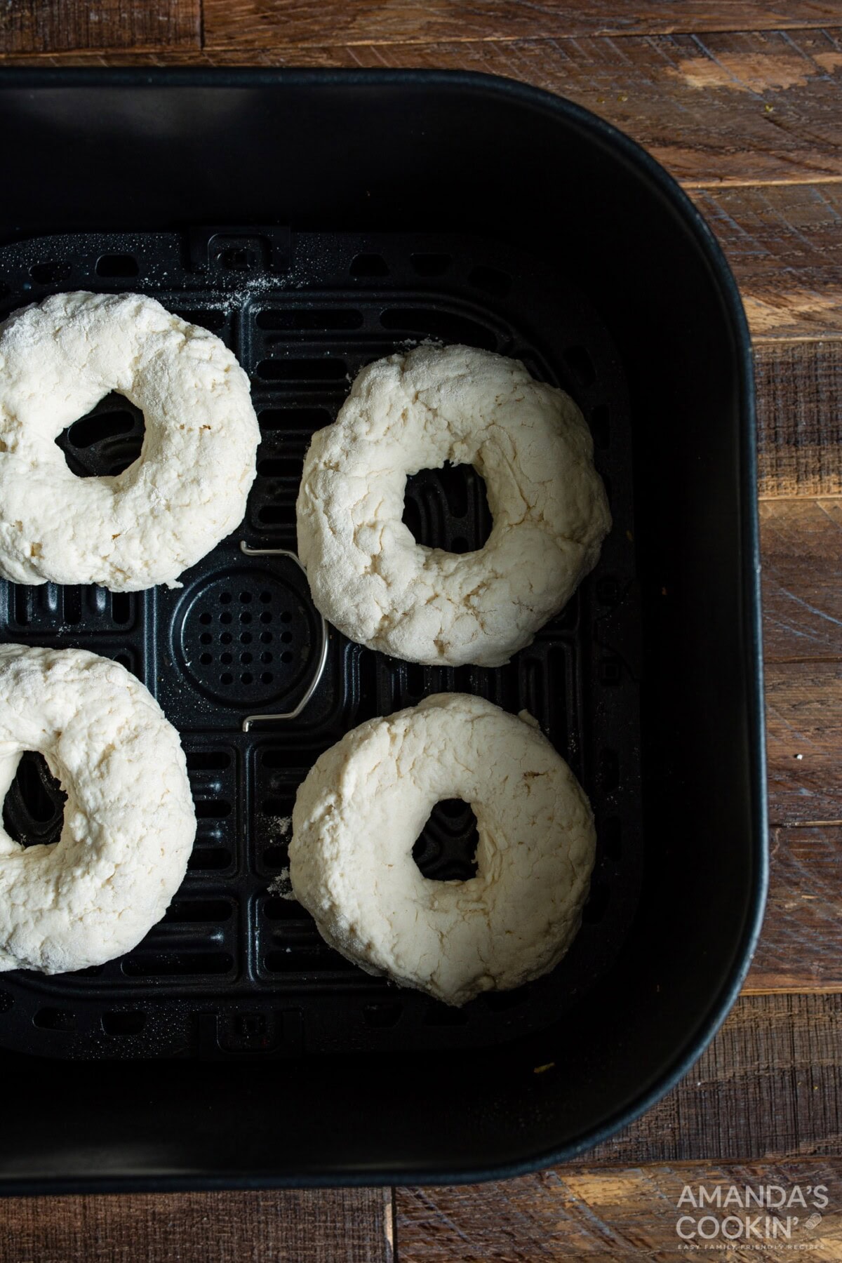 raw bagels in an air fryer basket