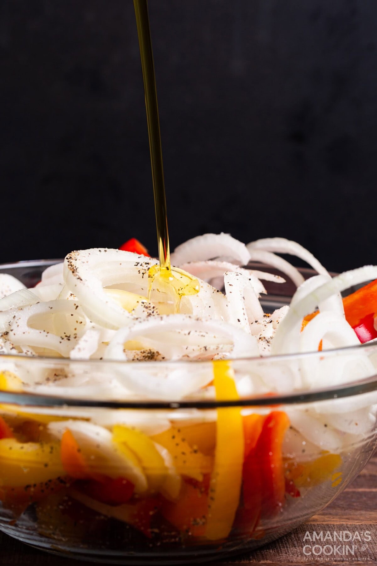 olive oil added to a bowl of peppers