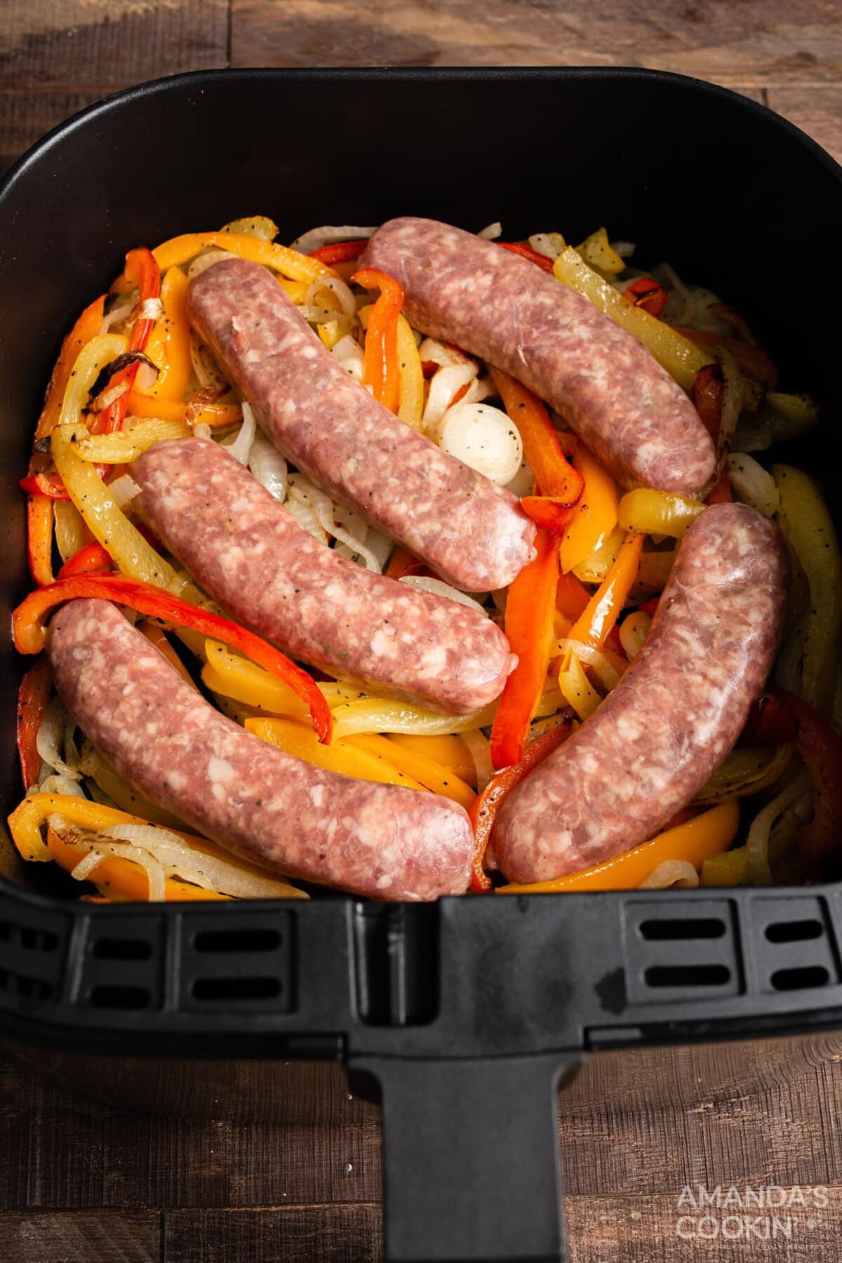 sausage and peppers in an air fryer basket