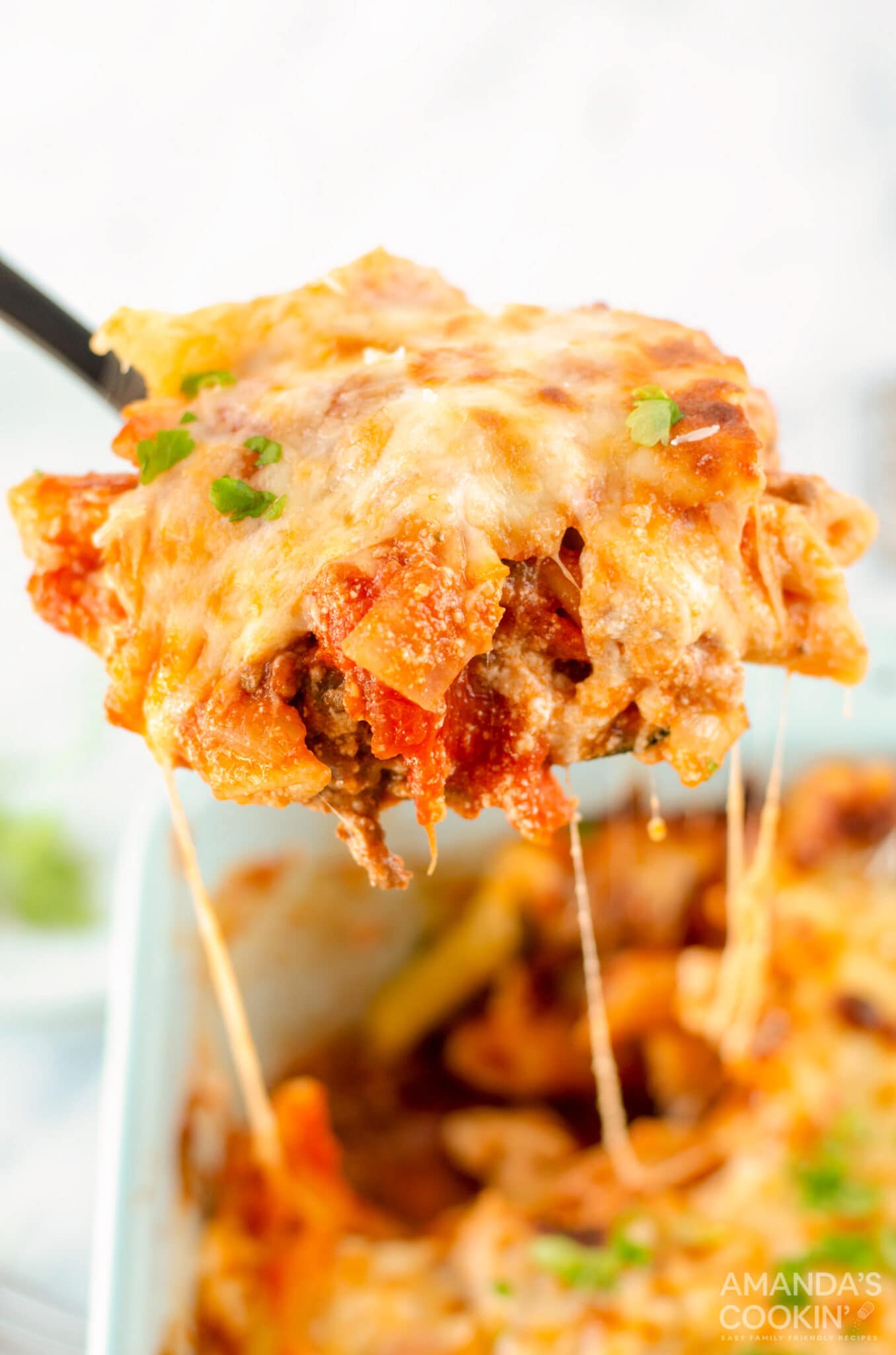 serving spoon of baked ziti