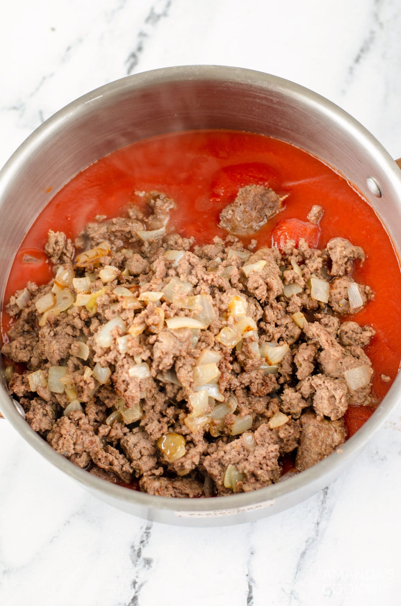 cooked ground beef added to tomato sauce