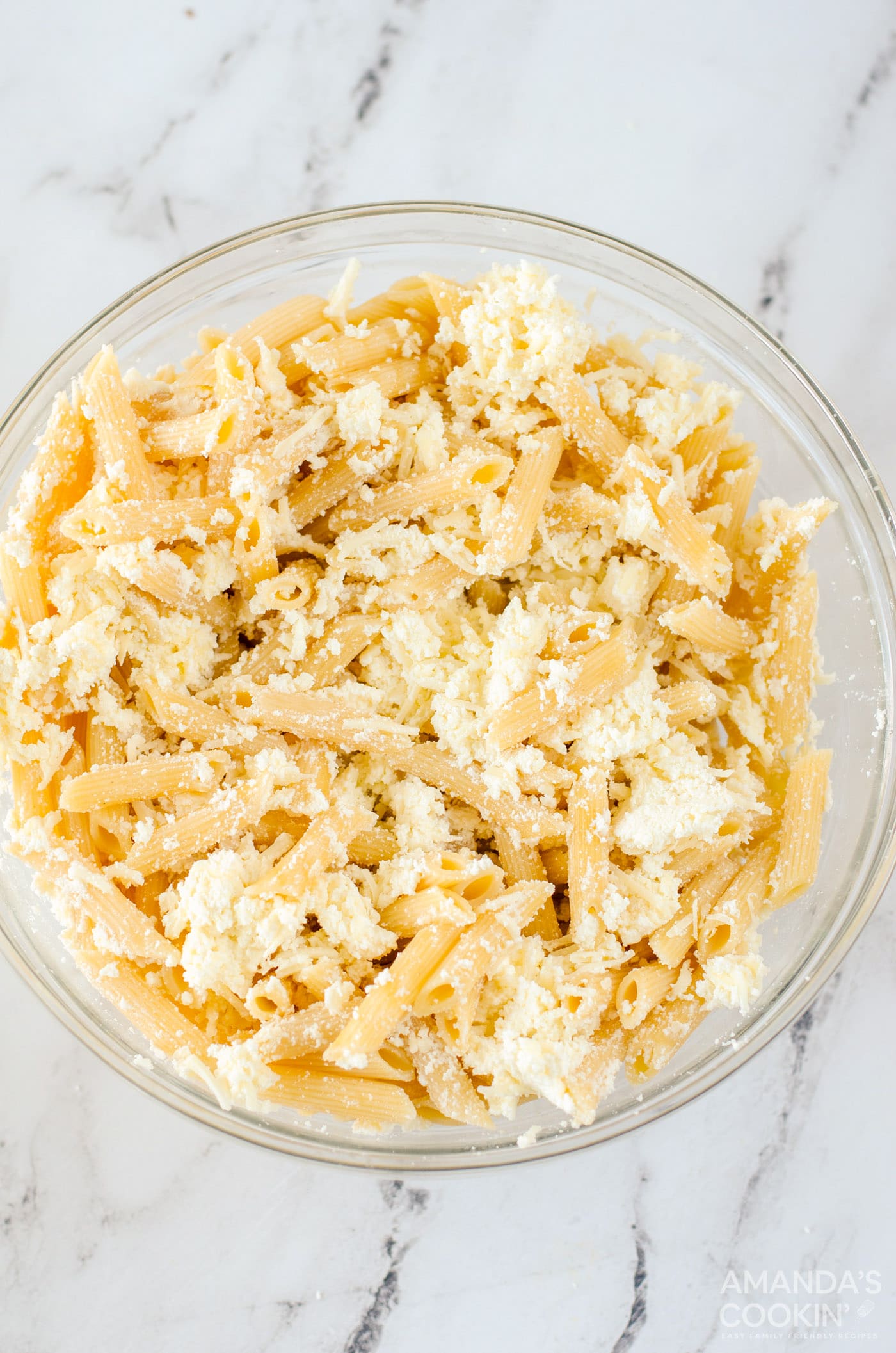 baked ziti noodles combined with cheese in a bowl
