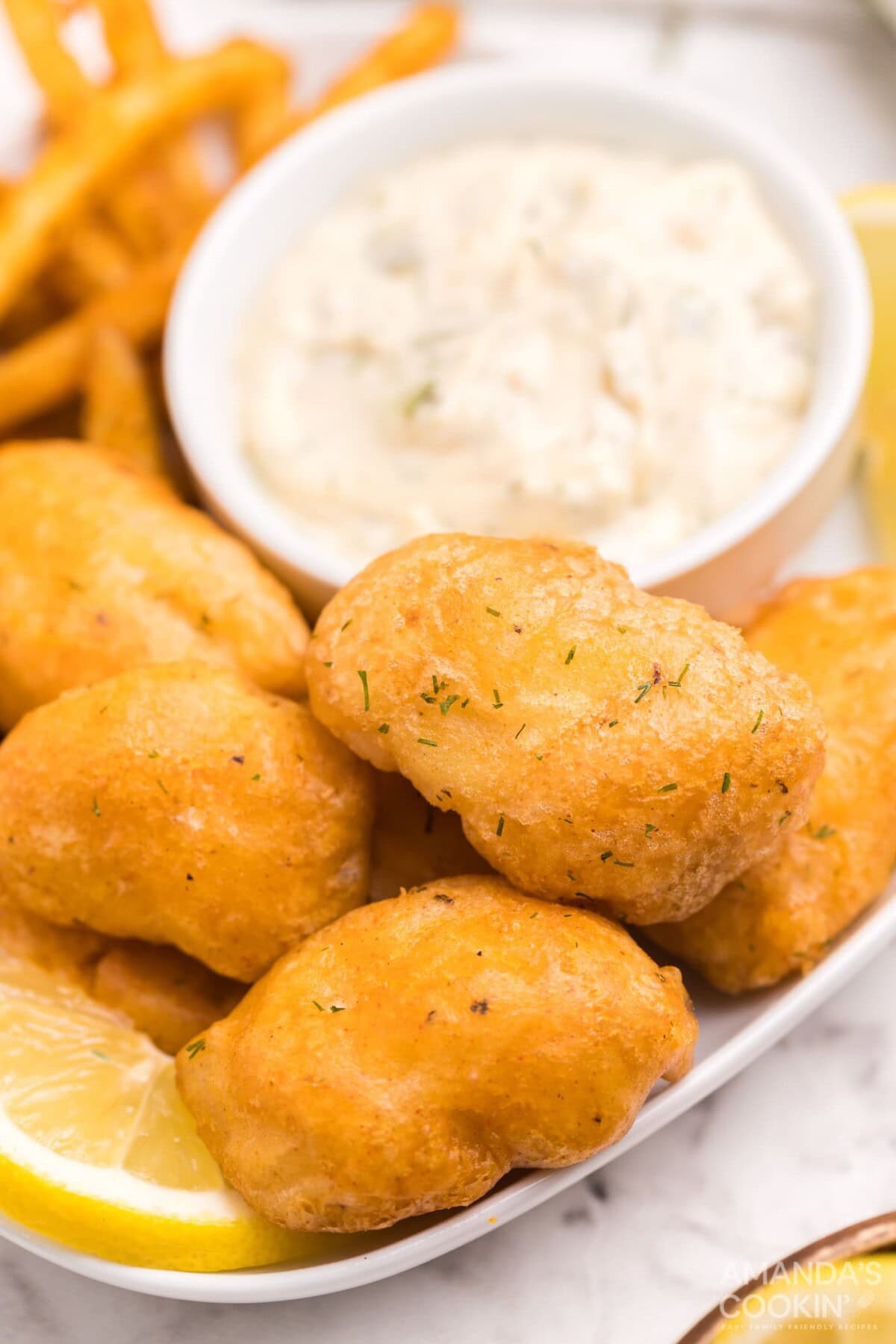 battered fish nuggets on a plate with tartar sauce