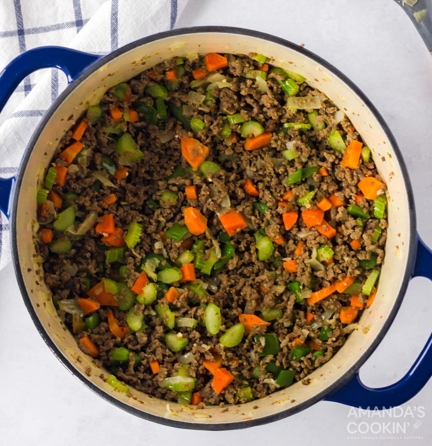 Ground beef, celery, carrot, onion, green bell pepper and garlic in a pot