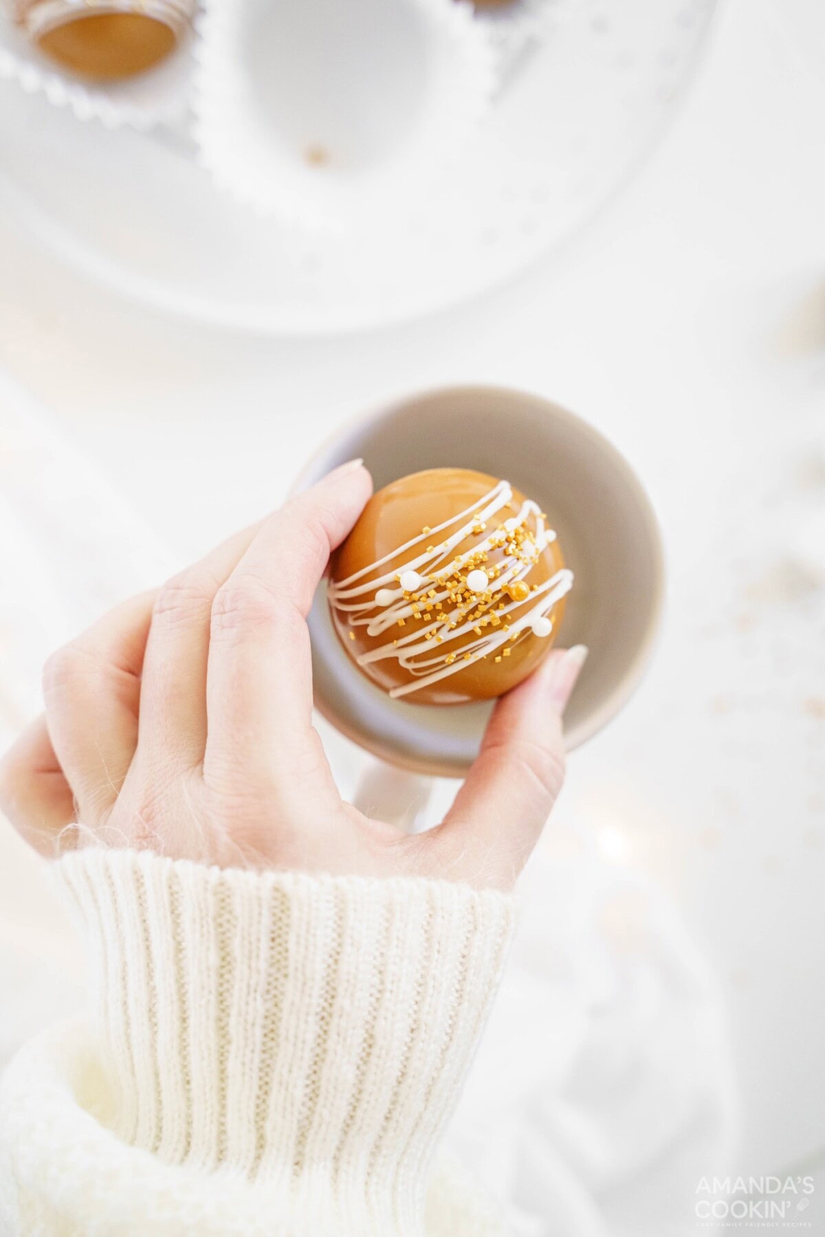 woman placing hot cocoa bomb in mug