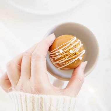 woman placing hot cocoa bomb in mug