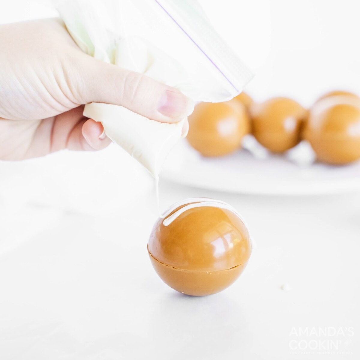 decorating hot cocoa bomb with white chocolate drizzles