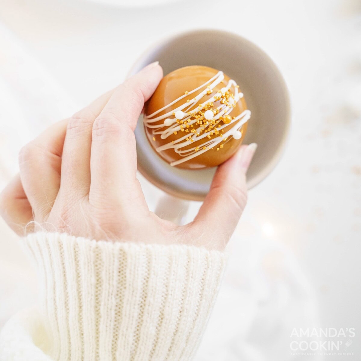 placing a hot cocoa bomb into a mug