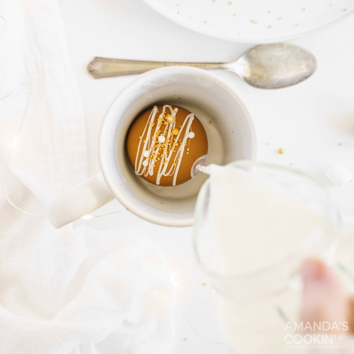 adding hot milk to a hot cocoa bomb