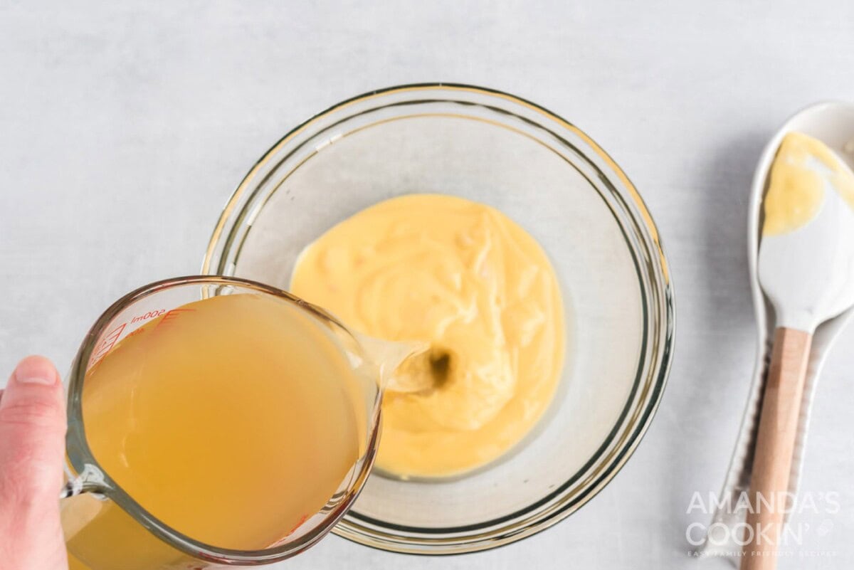 adding broth to mixing bowl