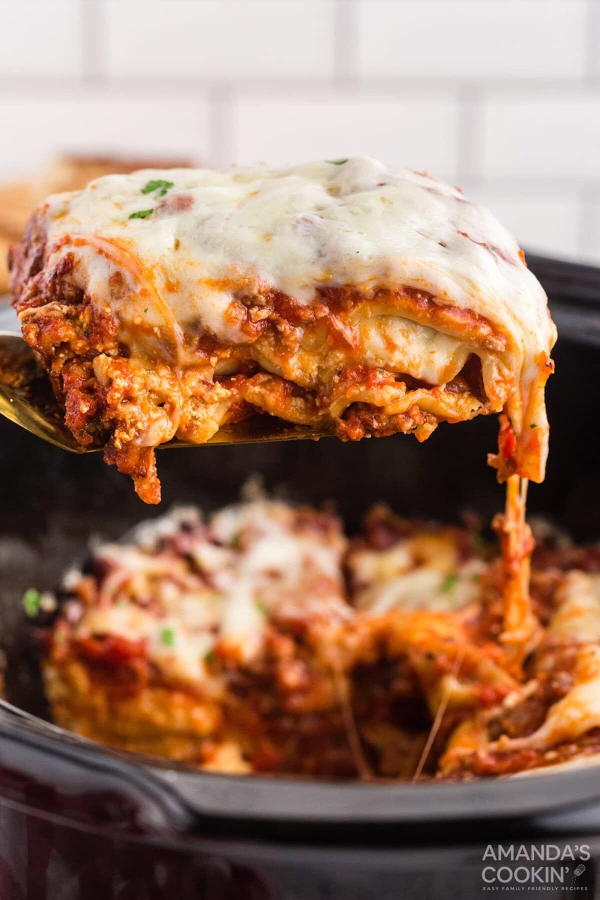 spatula lifting lasagna from a crockpot