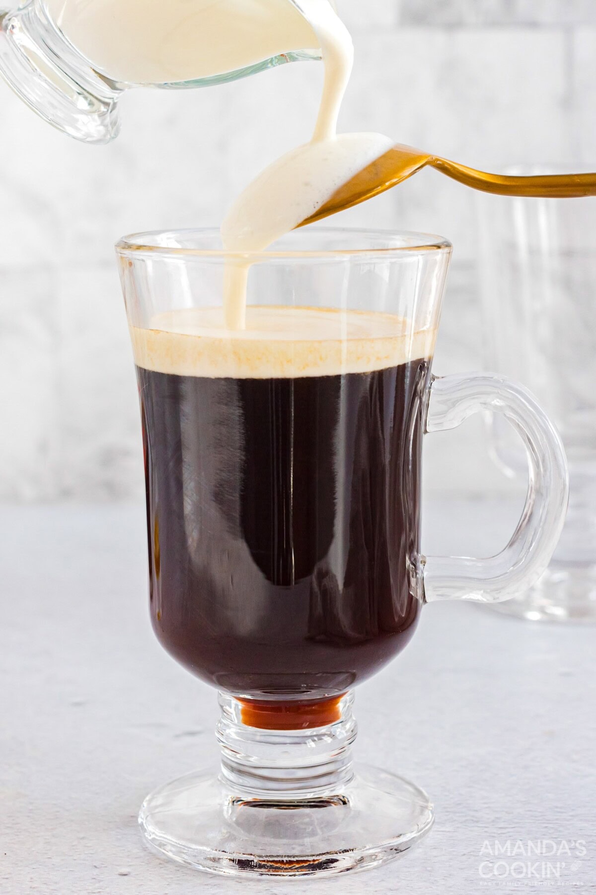 pouring cream over back of spoon into Irish coffee