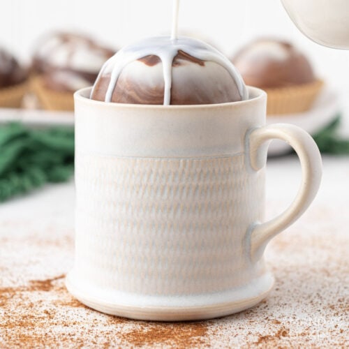 pouring milk over a hot cocoa bomb