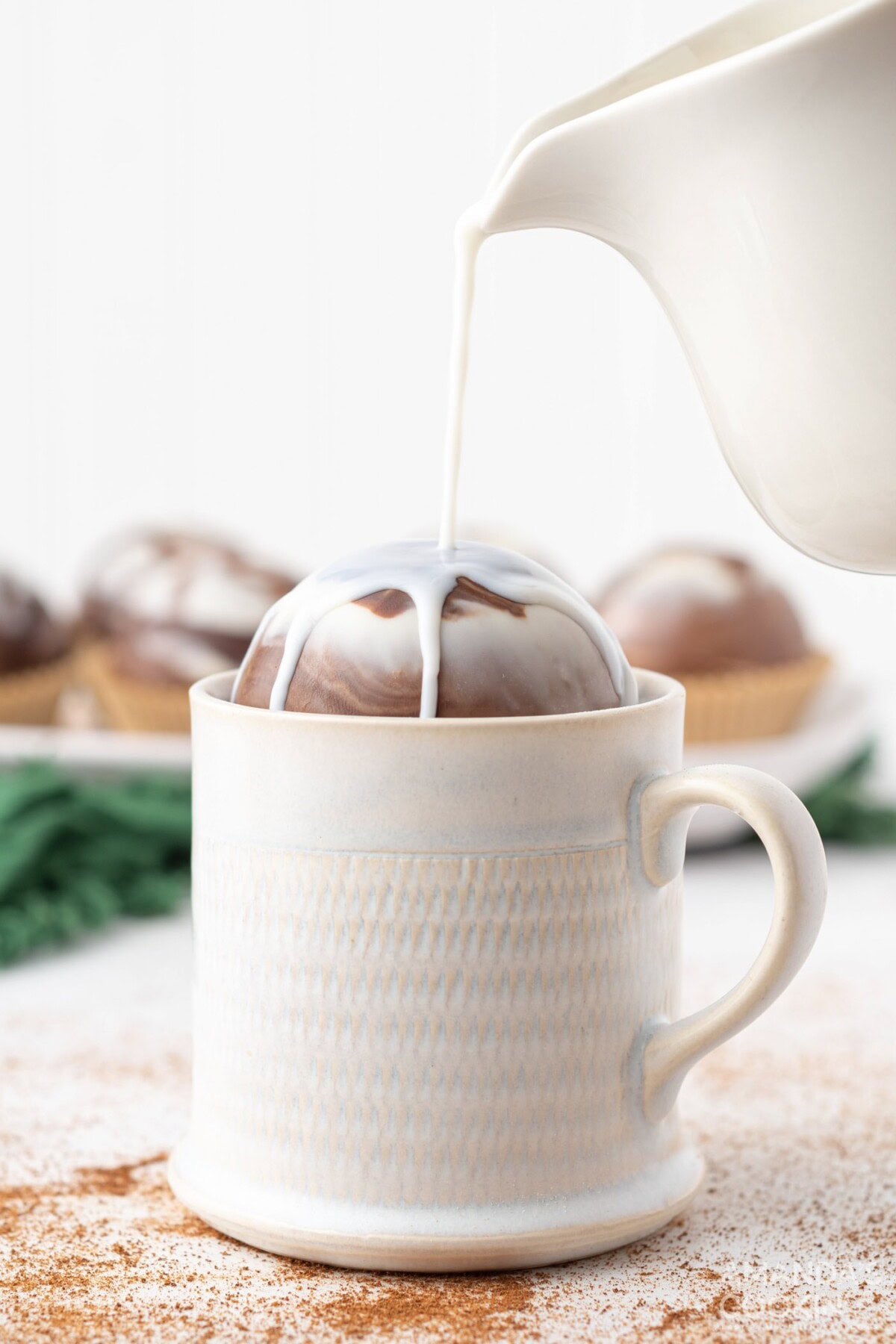 pouring milk over a hot cocoa bomb