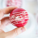 woman holding red velvet hot cocoa bomb