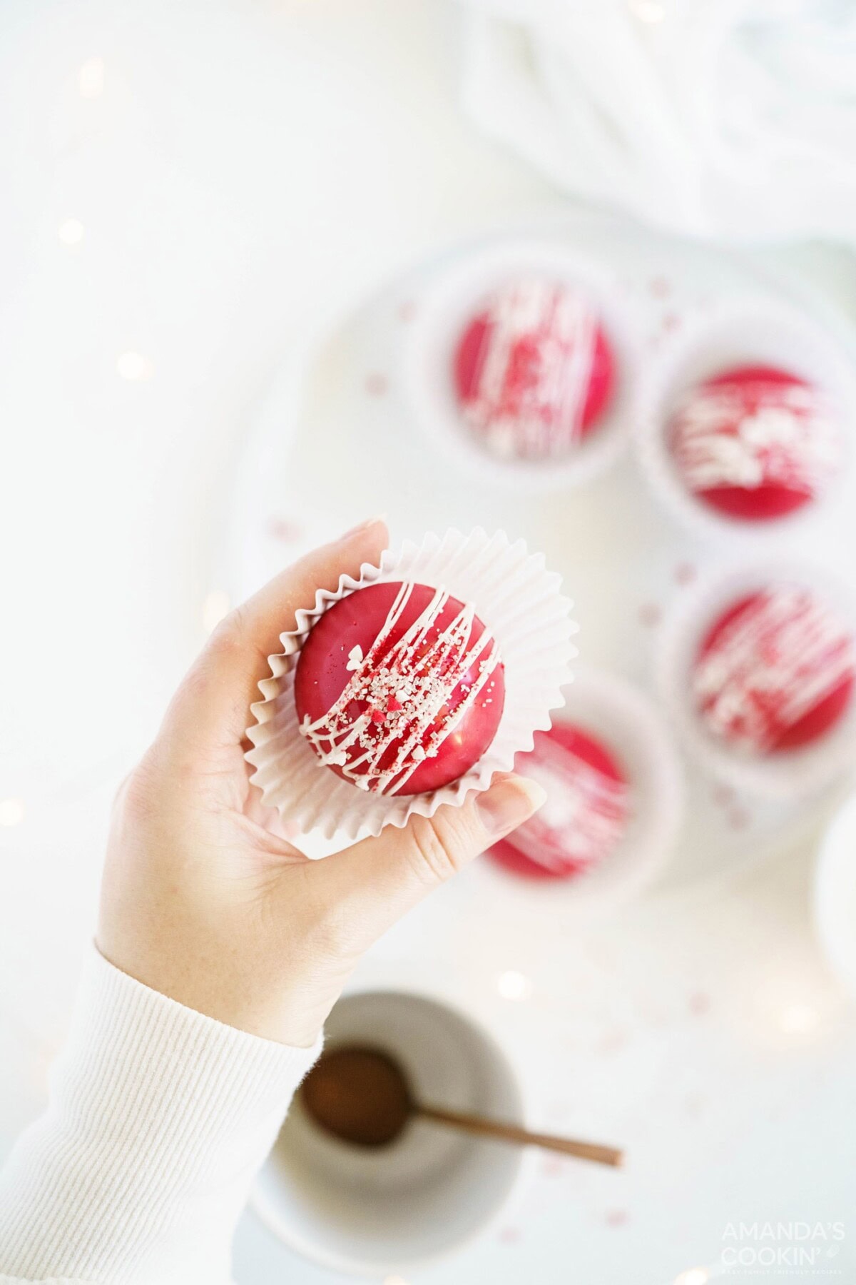 woman holding paper lined red velvet cocoa bomb