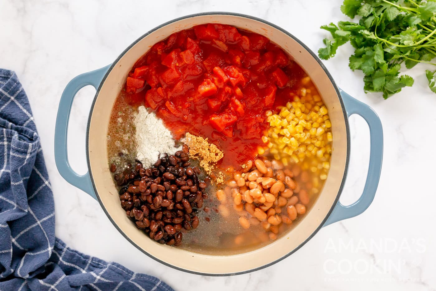 chilies, beans, broth, seasoning mixes, corn, and diced tomatoes in a pot